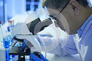 Scientist using microscope during experiment in laboratory, Science and technology healthcare concept