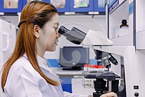 Scientist using a microscope in a laboratory.