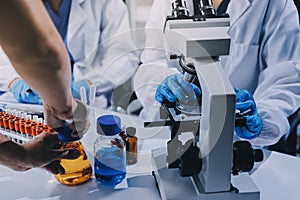 Scientist using microscope in laboratory. Close-up of a researcher& x27;s hands adjusting microscope in lab setting. Scienc