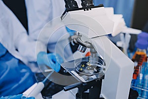 Scientist using microscope in laboratory. Close-up of a researcher& x27;s hands adjusting microscope in lab setting. Scienc