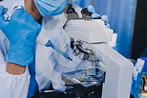 Scientist using microscope in laboratory. Close-up of a researcher& x27;s hands adjusting microscope in lab setting. Scienc