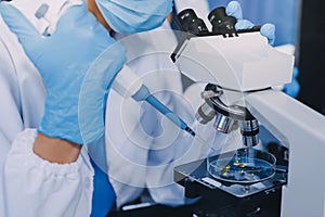 Scientist using microscope in laboratory. Close-up of a researcher& x27;s hands adjusting microscope in lab setting. Scienc