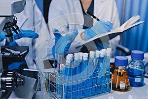 Scientist using microscope in laboratory. Close-up of a researcher& x27;s hands adjusting microscope in lab setting. Scienc