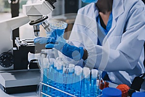 Scientist using microscope in laboratory. Close-up of a researcher& x27;s hands adjusting microscope in lab setting. Scienc