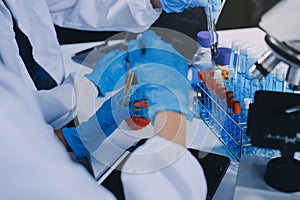 Scientist using microscope in laboratory. Close-up of a researcher& x27;s hands adjusting a microscope in a lab setting. Scienc