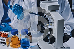 Scientist using microscope in laboratory. Close-up of a researcher& x27;s hands adjusting a microscope in a lab setting.