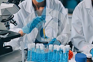Scientist using microscope in laboratory. Close-up of a researcher& x27;s hands adjusting a microscope in a lab setting.