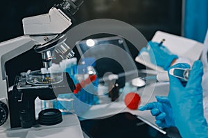 Scientist using microscope in laboratory. Close-up of a researcher's hands adjusting a microscope in a lab setting.