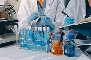 Scientist using microscope in laboratory. Close-up of a researcher& x27;s hands adjusting a microscope in a lab setting.