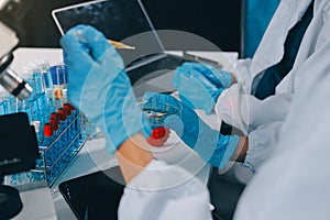 Scientist using microscope in laboratory. Close-up of a researcher& x27;s hands adjusting a microscope in a lab setting.