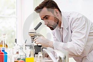Scientist is using microscope in a laboratory during research