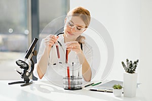 Scientist using a microscope in a laboratory, Testing for Coronavirus Covid19 vaccine