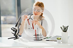 Scientist using a microscope in a laboratory, Testing for Coronavirus Covid19 vaccine