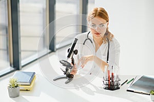 Scientist using a microscope in a laboratory, Testing for Coronavirus Covid19 vaccine.