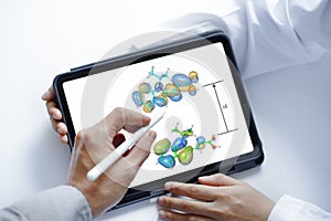Scientist Using a Tablet to explainthe electron density between two molecular model orbitals Orbitals