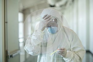 Scientist wearing protective gear holding a  test result for coronavirus