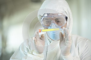 Scientist wearing protective gear holding a  test result for coronavirus