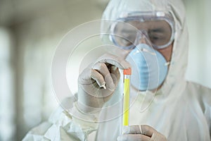 Scientist wearing protective gear holding a  test result for coronavirus