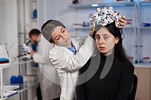 Scientist woman putting eeg headset on woman patient head during neurology experiment