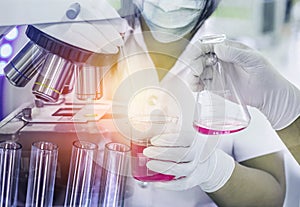 Scientist woman research carrying chemistry liquid to test tube with hand scientist holding flask with microscope equipment for re