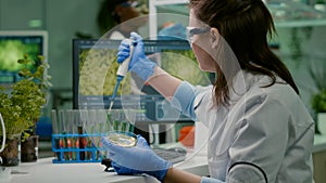 Scientist woman taking genetic solution from test tube with micropipette