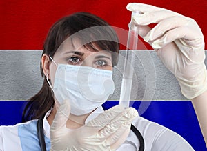 Scientist woman with test tube Coronavirus or COVID-19 against Netherlands flag. Research of viruses in laboratory