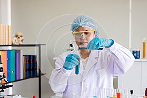 Scientist woman working and putting medical chemicals sample in test tube at laboratory