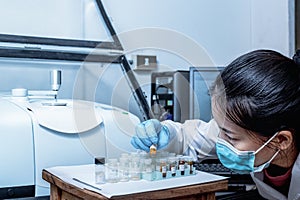 Scientist Women Check Sample in Vials for Analysis by Fourier Transform Infrared Spectroscopy FTIR Instrument