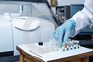 Scientist Women Check Sample in Vials for Analysis by Fourier Transform Infrared Spectroscopy FTIR Instrument