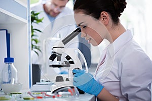 Scientist during work with microscope at modern biological laboratory