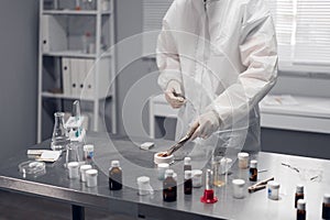 A scientist working in a chemical laboratory. Laboratory equipment and glassware containing chemical liquids in the