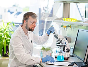 Scientist working in lab. Doctor making microbiology research. Laboratory tools: microscope, test tubes, equipment