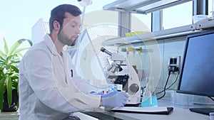 Scientist working in lab. Doctor making microbiology research. Laboratory tools: microscope, test tubes, equipment