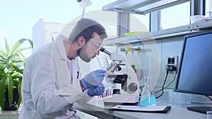 Scientist working in lab. Doctor making microbiology research. Laboratory tools: microscope, test tubes, equipment