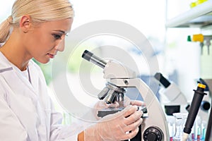 Scientist working in lab. Female doctor making medical research. Laboratory tools: microscope, test tubes, equipment