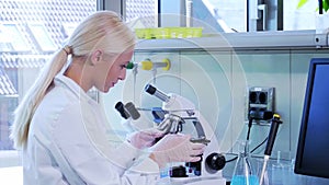 Scientist working in lab. Female doctor making medical research. Laboratory tools: microscope, test tubes, equipment