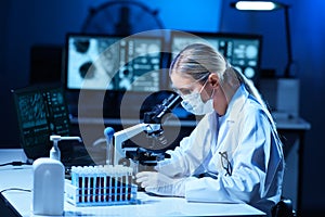 Scientist working in lab. Female doctor making medical research. Laboratory tools: microscope, test tubes, equipment