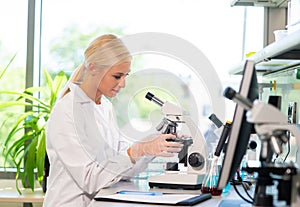 Scientist working in lab. Female doctor making medical research. Laboratory tools: microscope, test tubes, equipment