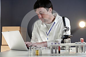 Scientist at workspace in laboratory with microscope, computer, and laboratory tools. Bio technology. Med students stuff. Medical