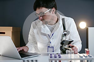 Scientist at workspace in laboratory with microscope, computer, and laboratory tools. Bio technology. Med students stuff. Medical