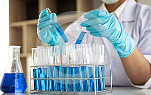 Scientists are carrying blue chemical test tubes to prepare for the determination of chemical composition and biological mass in a