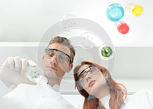 Scientists examining petri dish in lab