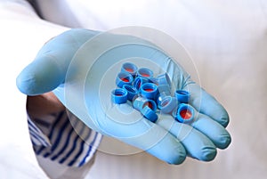 Scientists hand holds disposable caps
