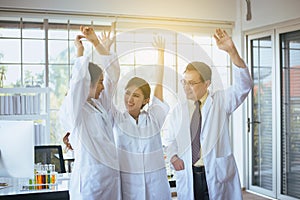 Scientists hands rais up,Group of diversity people teamwork in laboratory,Success and reserch working photo