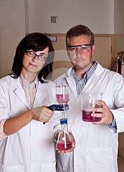 Scientists holding labware