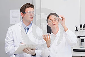 Scientists looking attentively at pill