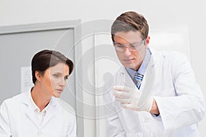 Scientists looking attentively at test tube