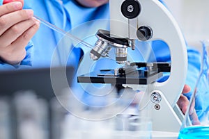 Scientists are preparing samples To examine the specimens with a microscope in lab, Dropping the solution on to a glass plate with