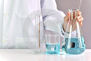 Scientists researching in laboratory, Chemist holding scientific glassware equipment