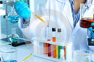 Scientists researching in laboratory. Professional science focus pipetting solution into the glass cuvette